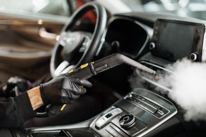 Detailer sanitizing car steering wheel and gear shift with interior deep clean service in Montreal and Laval