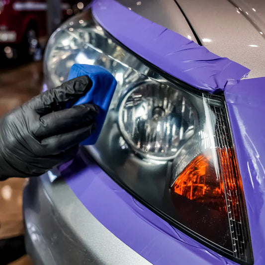 Car detailing expert restoring a headlight in Montreal using professional polishing and UV protection.